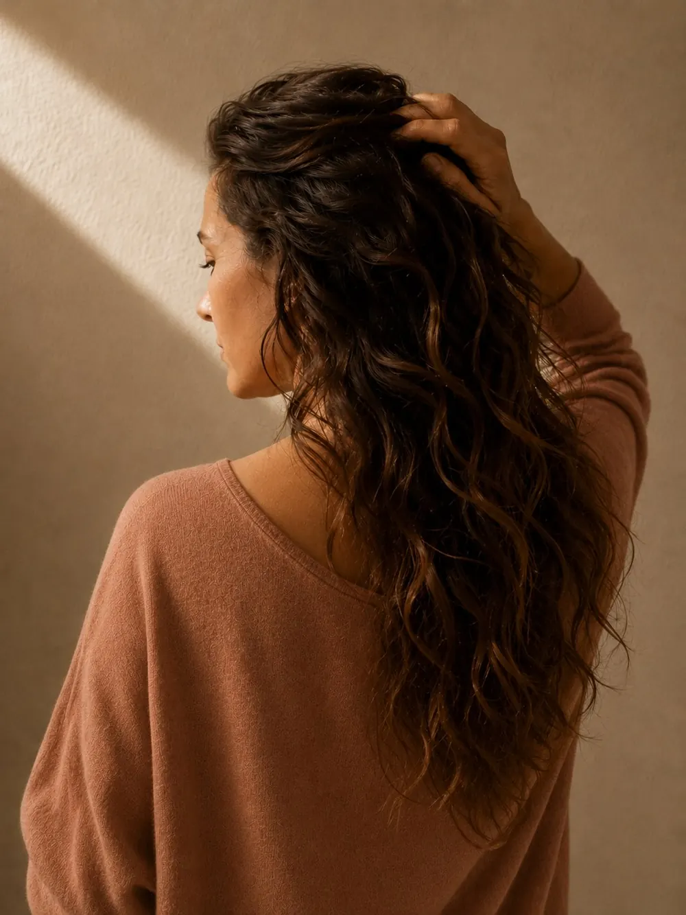 Femme de profil, la main dans ses cheveux, lumière chaude